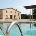Piscina exterior con sombrilla.