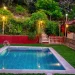 Piscina con cesped y jardin